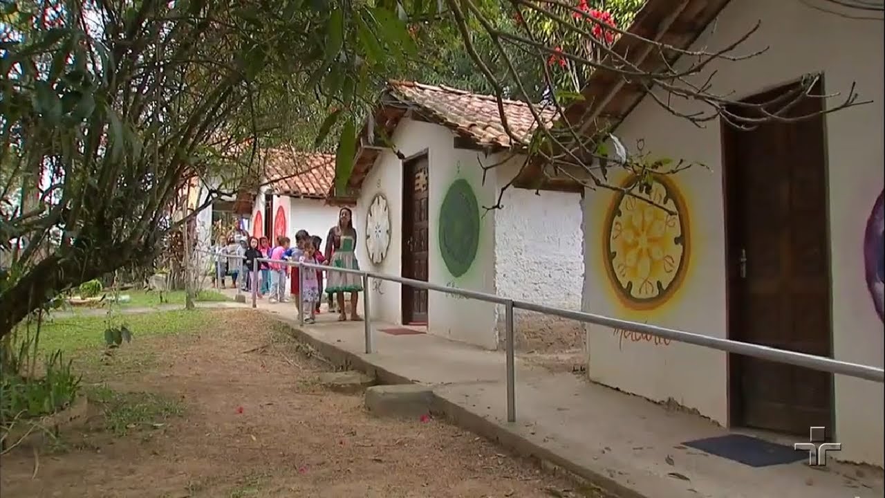 Professora de jardim passeando com os estudantes pela escola.