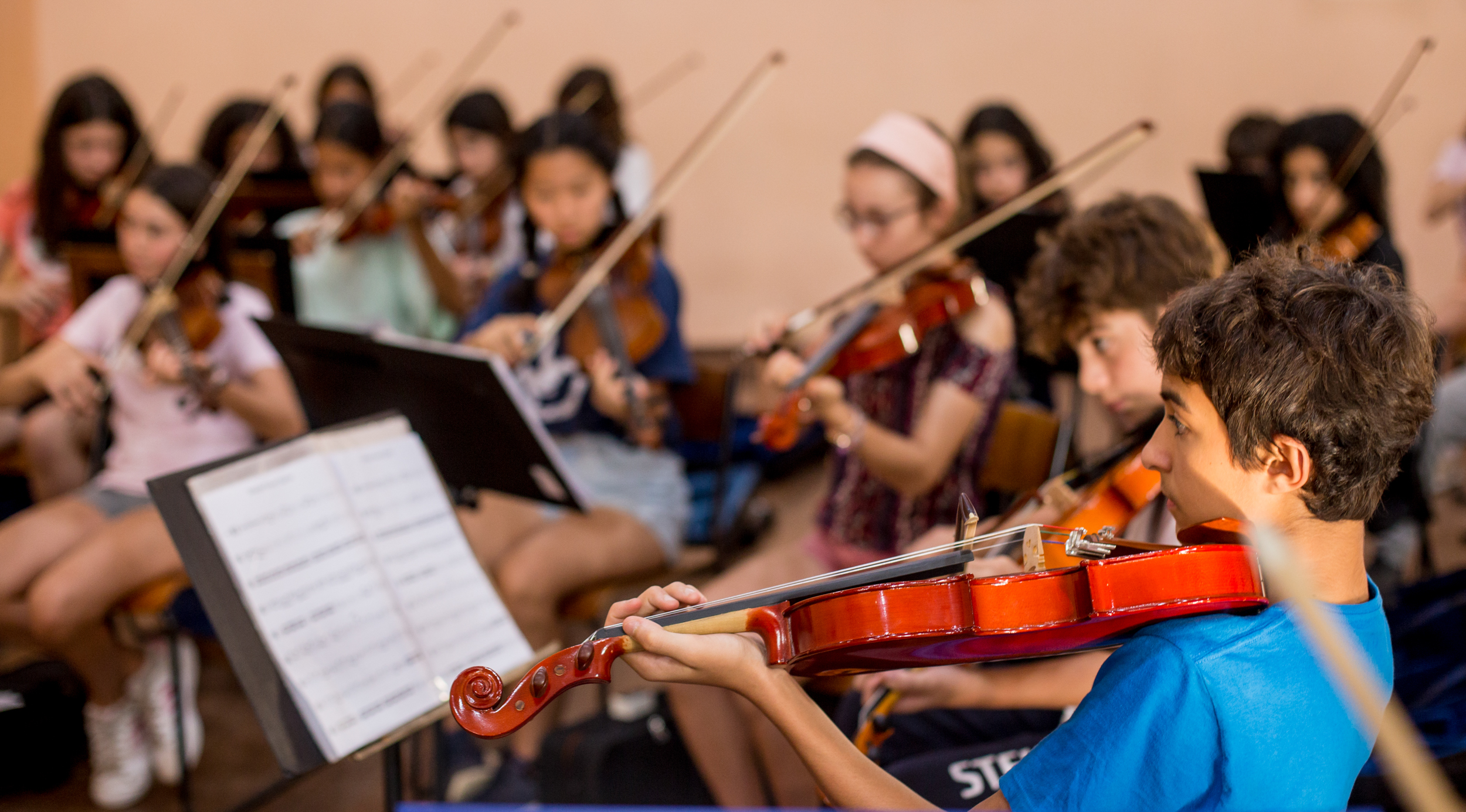 Alunos tocando violino em grupo durante aula de música na Escola Waldorf Rudolf Steiner.
