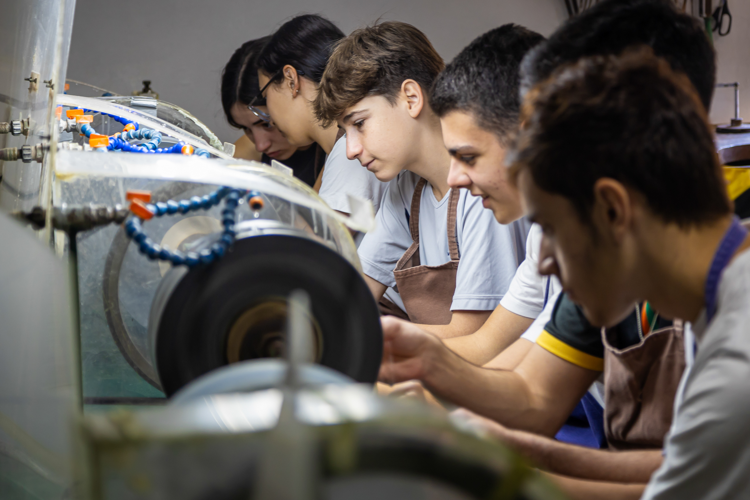 Alunos em oficina de lapidação de pedras com equipamentos especializados na Escola Waldorf Rudolf Steiner.